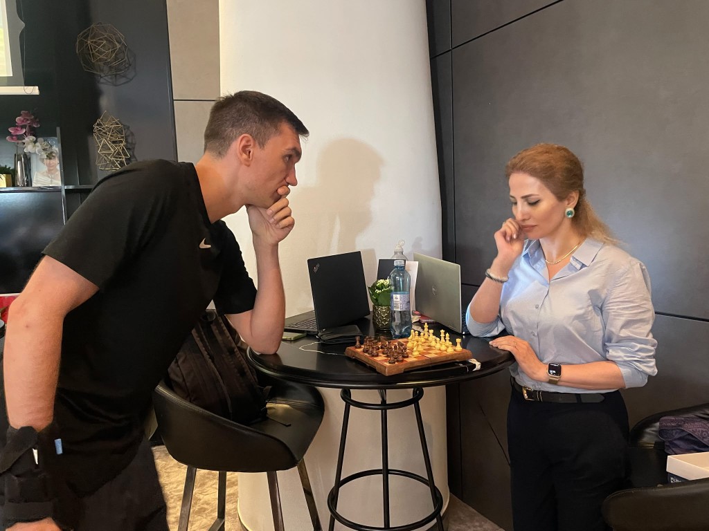 Samira und Viktor spielen Schach während einer Pause zwischen den Meetings