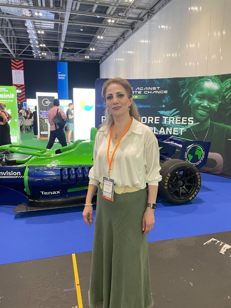 Samira Richardson at Reset Connect London, in front of the Envision Formula E "Race Against Climate Change" display